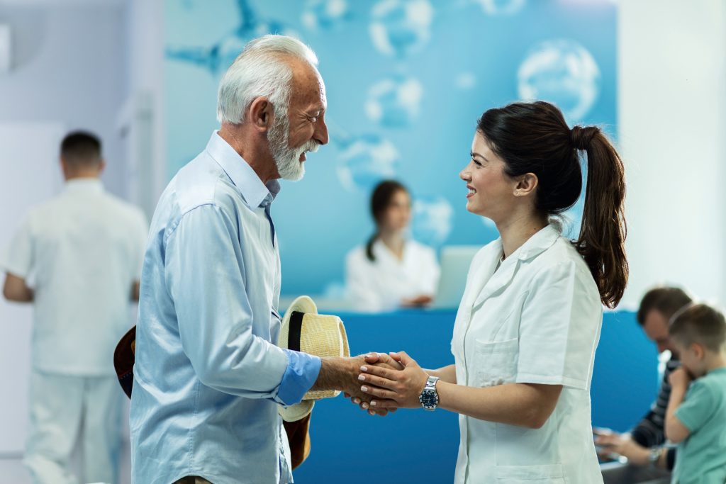 Young doctor and senior patient shaking hands