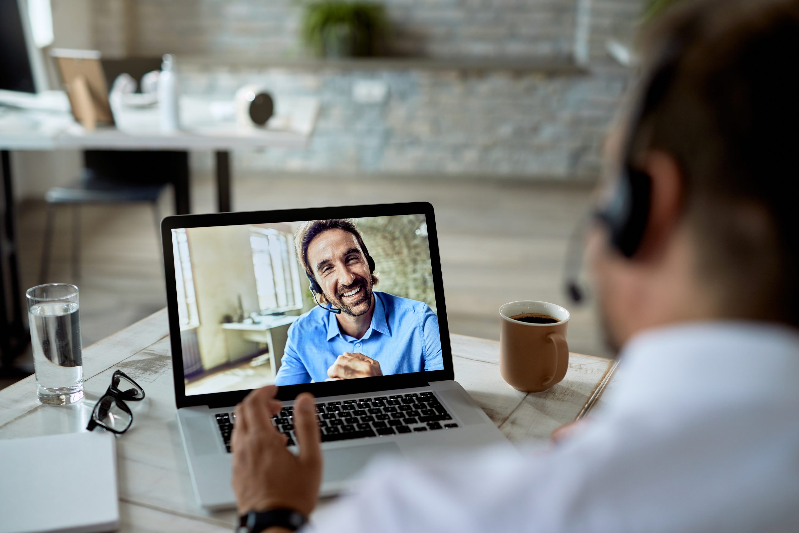 Man wearing headphones and doing online meeting