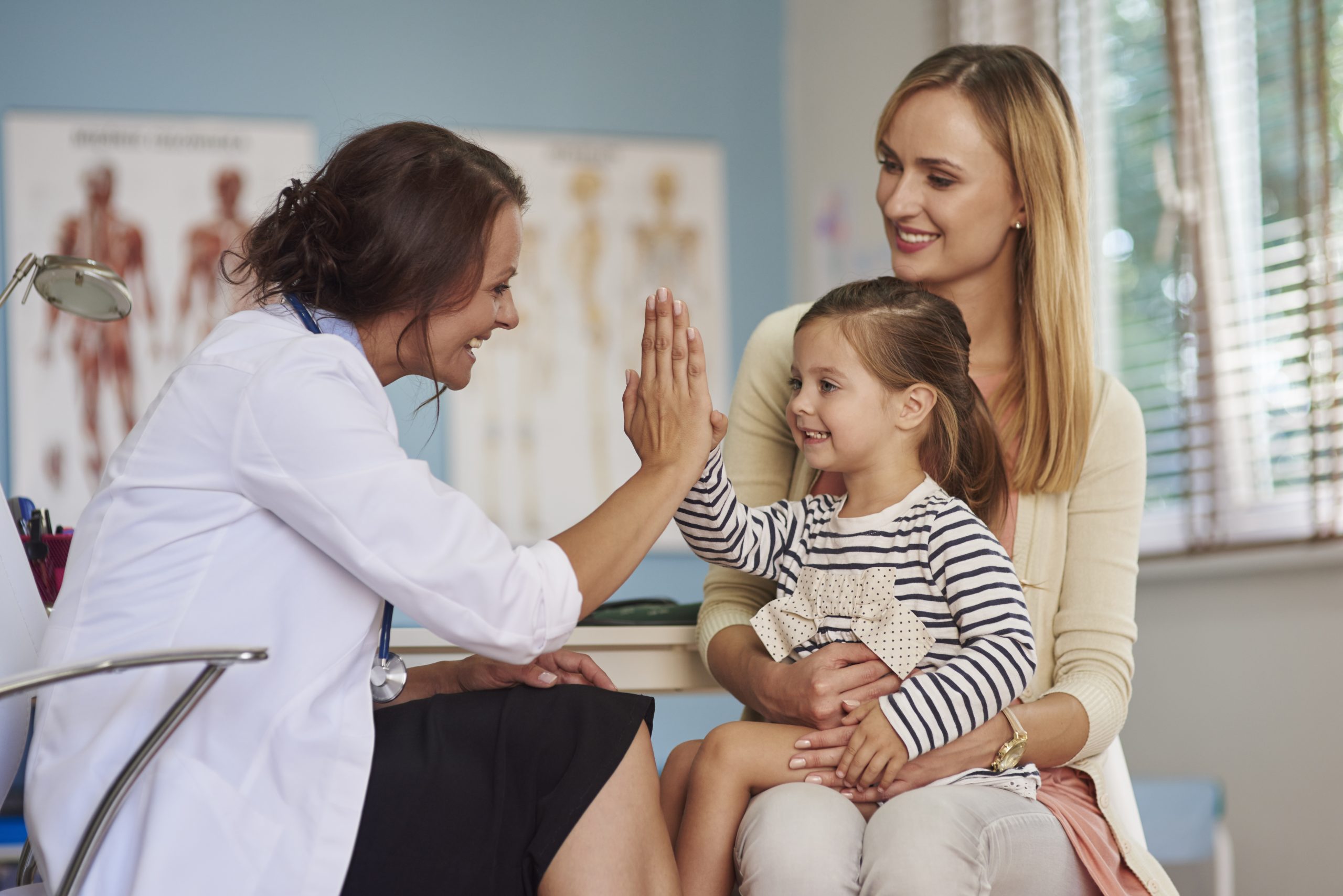 Doctor similing and giving high five with little patient